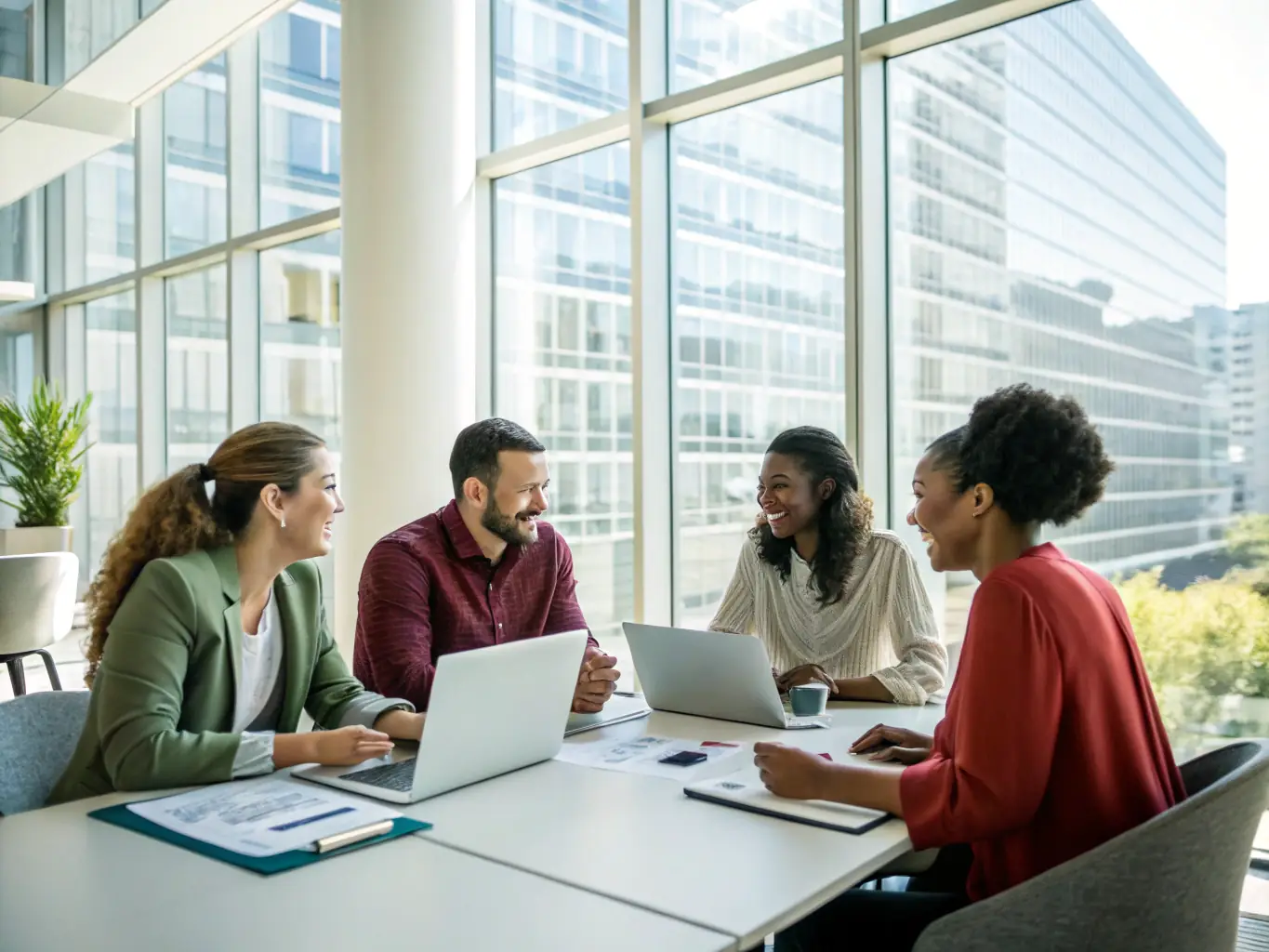 A high-angle photograph of a diverse group of policy researchers collaborating around a table filled with documents and laptops, bathed in natural light from a nearby window, symbolizing governance and public administration reform.